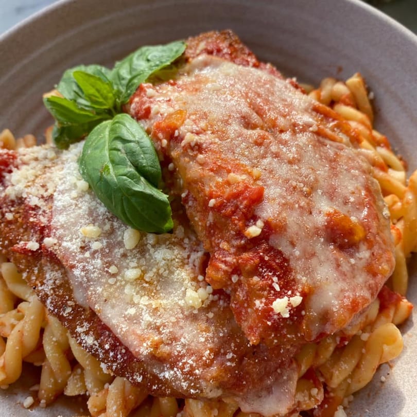 Becca's Kitchen's chicken parmesan with fusilli pasta, tomato sauce, melted cheese, and fresh basil.